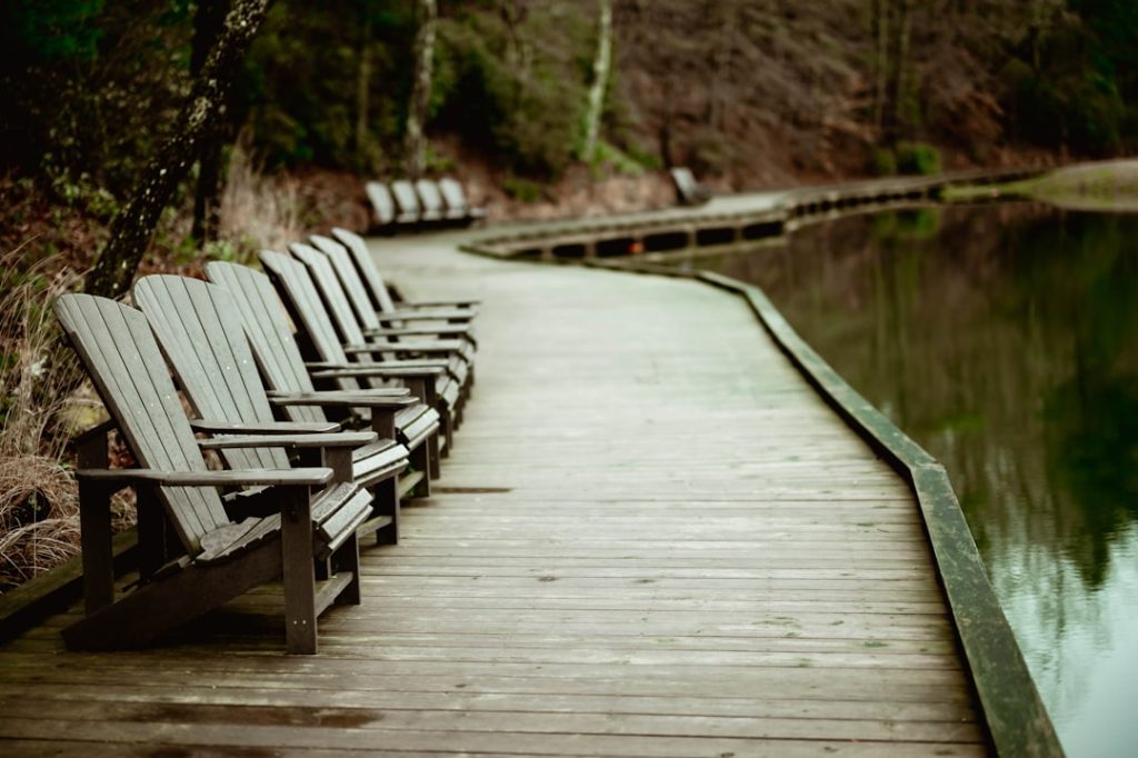 a-row-of-chairs-sitting-on-top-of-a-wooden-pier-2fzfcfqfkua