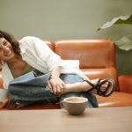 A Woman Sitting On A Couch With A Cup Of Coffee 3gofxlhkpxq 150x150