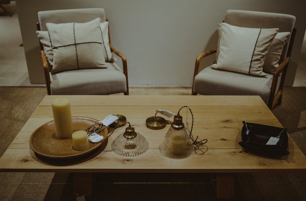 a-wooden-table-topped-with-two-chairs-and-a-tray-of-candles-gxfa1q2i0bg